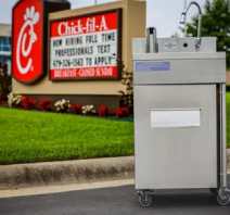 A stainless steel sink sitting in front of a chick-fil-a sign.