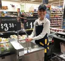 A woman standing behind the counter of a store.