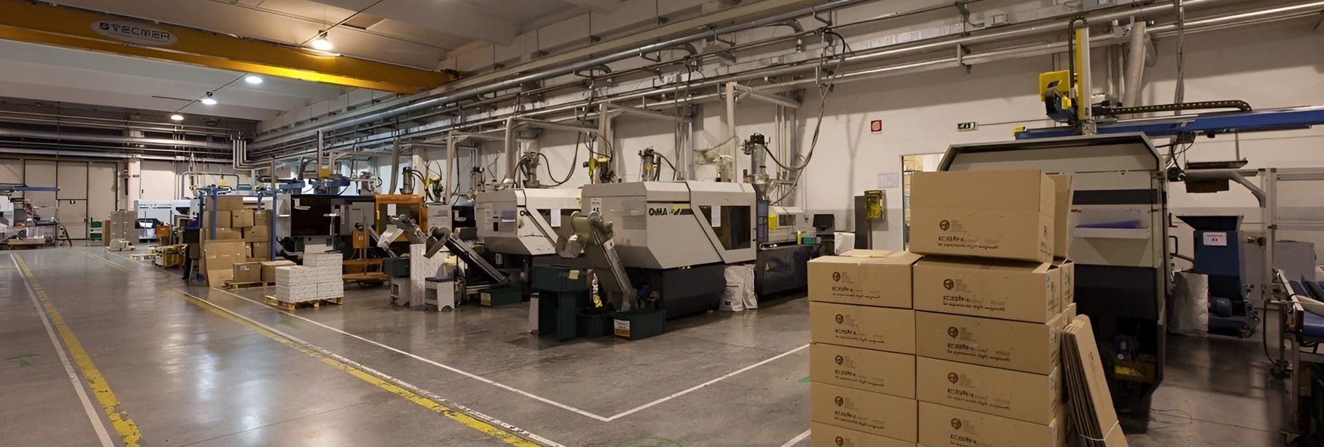 A factory with machines and boxes on the floor.